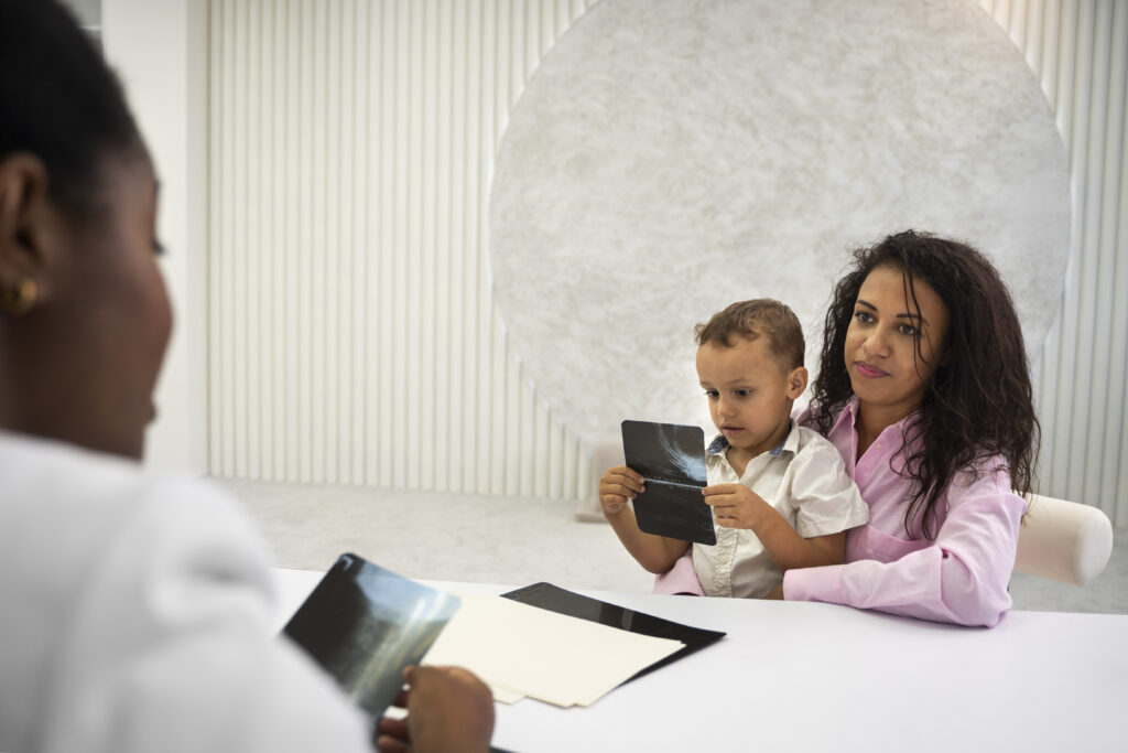 A diverse family speaking with a genetic counselor in a comfortable office setting about their baby's health.